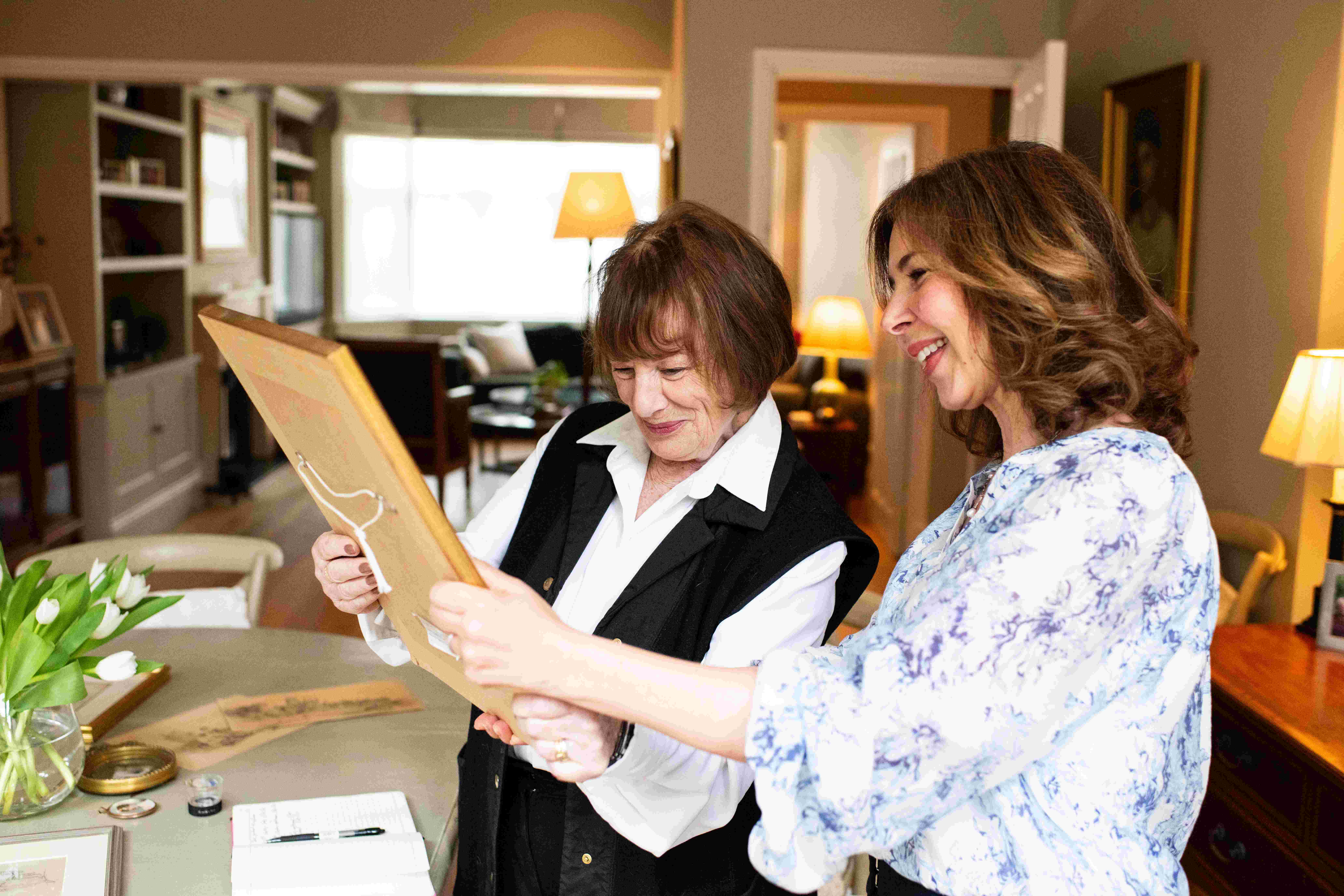two women looking at a painting